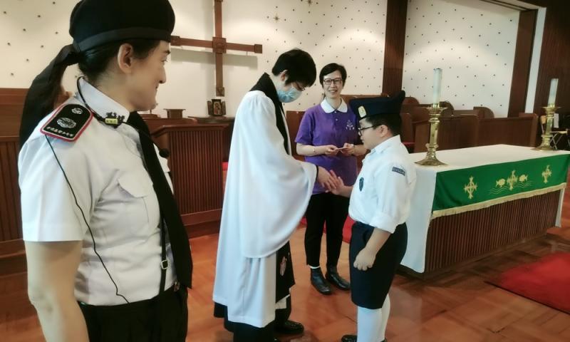 四年級代表接受梁麗娥牧師頒發的隊員證